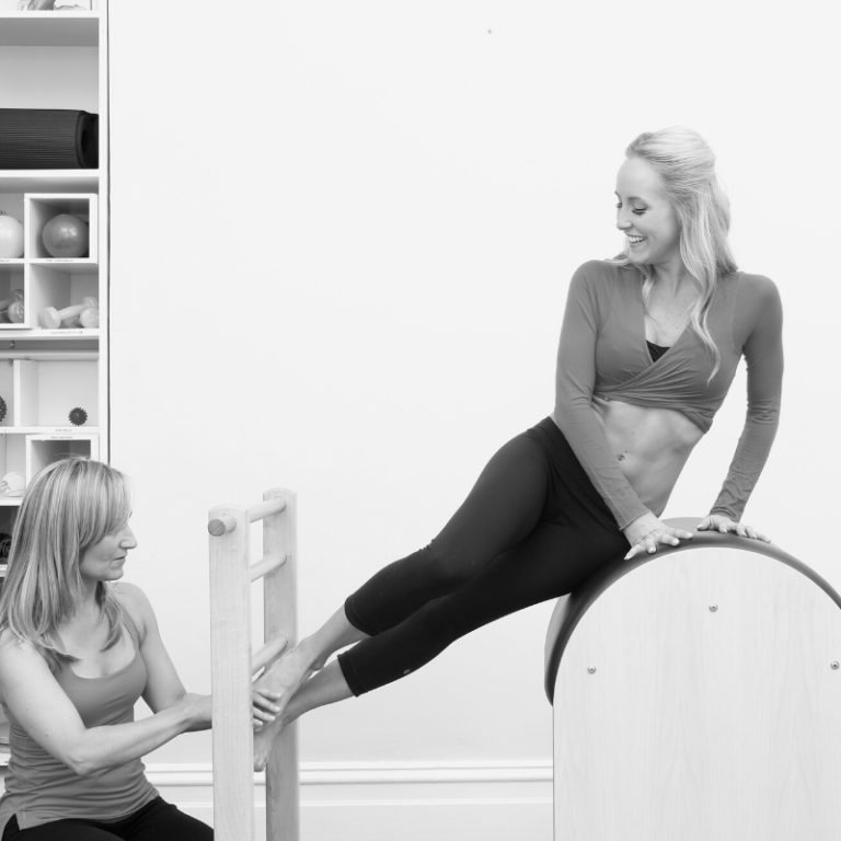 Person supplementing her online Pilates training course with additional in-person training on the Pilates Ladder Barrel